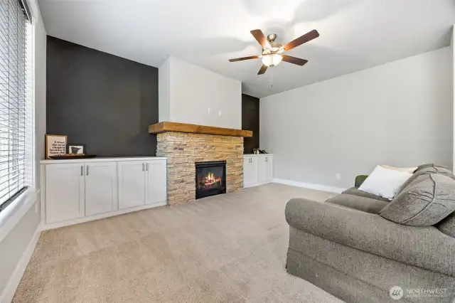 Spacious living room with built-ins around stone gas fireplace/