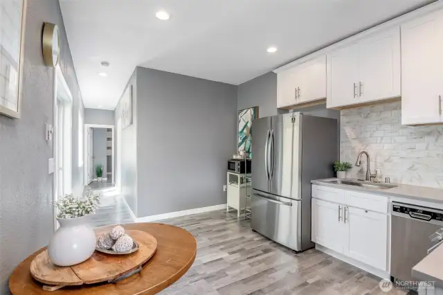 Main floor kitchen with quartz counters, stainless appliances and laminate flooring.