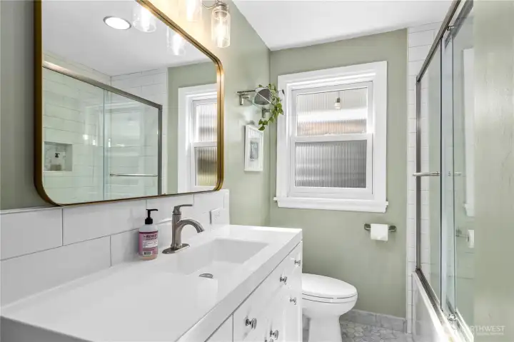 The main level bathroom has just be remodeled. It features a spacious new tub/shower with glass doors.