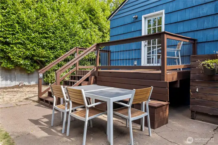 The fully fenced back yard has multiple gathering areas.