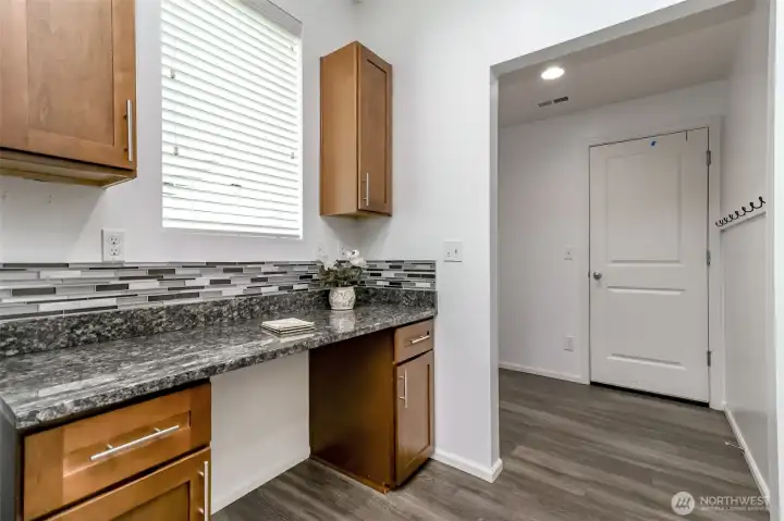 On the other side of the refrigerator is the built in desk at the end of the kitchen. The room to the right of the desk is a mud room just off the garage.