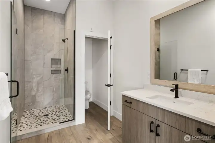 Second 3/4 bathroom featuring a spacious, beautifully tiled shower.