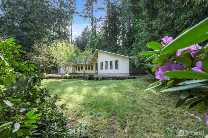 Freshly painted exterior complements the natural surroundings beautifully.