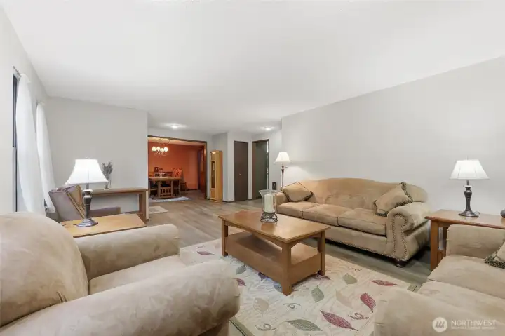 This angle provides a view of the entry, dining room ahead with entry to kitchen and family room, quick access to kitchen in the visible doorway, and hallway to bedrooms on right.