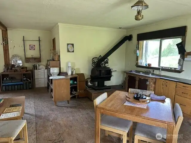 Enter into your kitchen from the east deck.Includes an Orley woodstove with 2 cook tops, double kitchen sink, alcohol stove top and dinng table for 4.