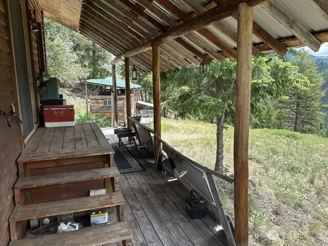 Stairs to the front deck. The 5th wheel trailer in the background has most recently been used for storage but could be renovated as a guest house.