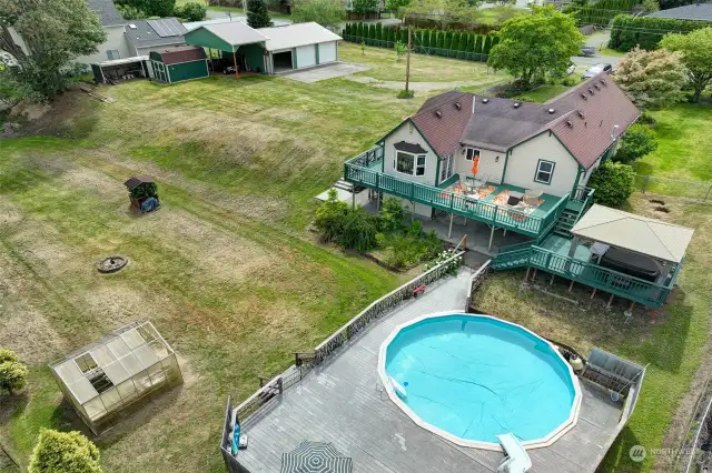 The yard is fully fenced, and there is also a greenhouse and firepit on the property.