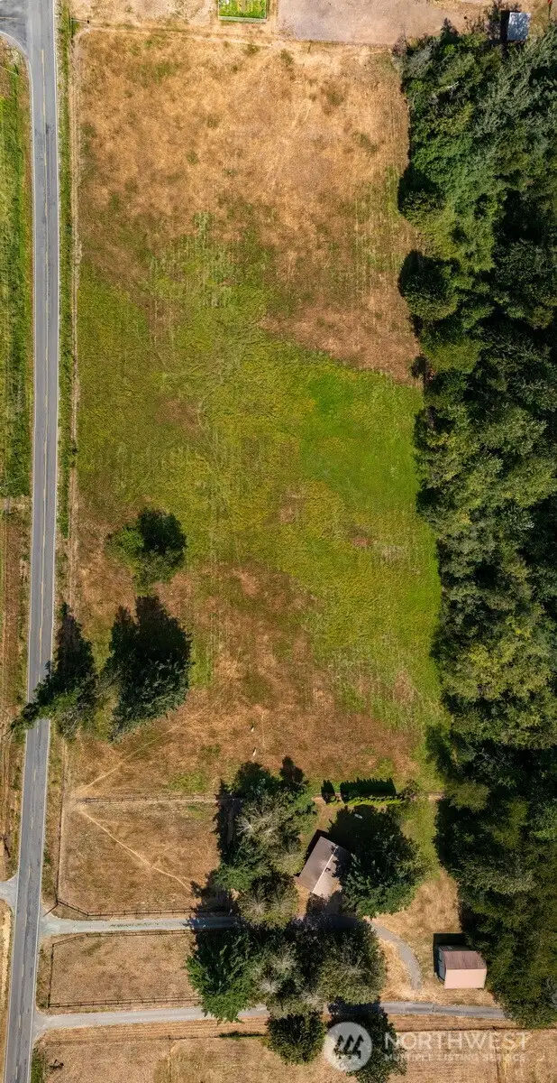 Looking down at the property with the three pastures with run-in sheds and paddocks.