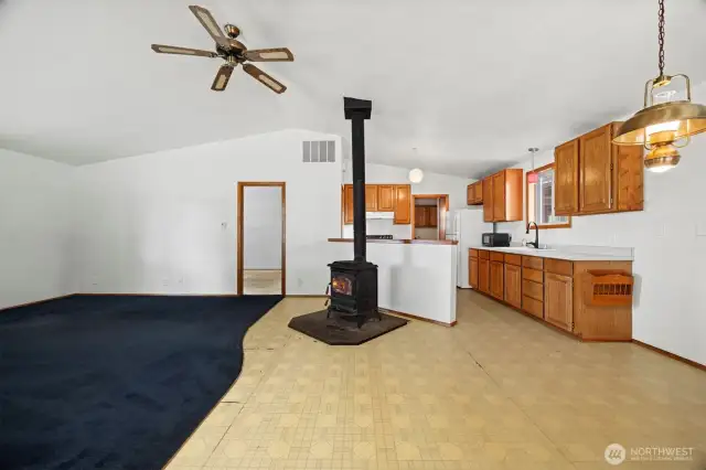 Inside you will find an open floor plan with vaulted ceilings and a fan to circulate the heat from the freestanding wood stove. The flooring does need to be replaced.