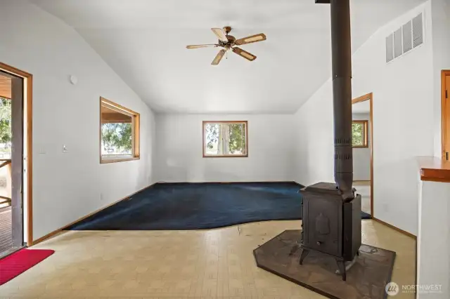 Looking at the living room with the wood stove that can heat the entire home.