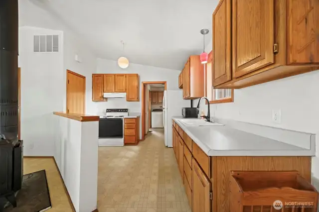 Looking at the kitchen with the back porch/laundry room beyond.