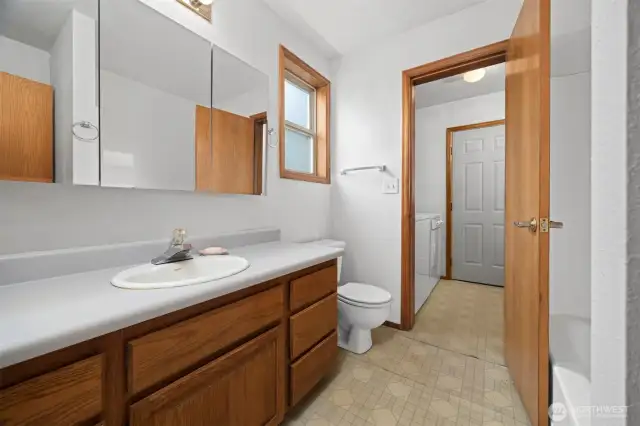 Looking through the full bath to the laundry/mud room and the back door beyond.