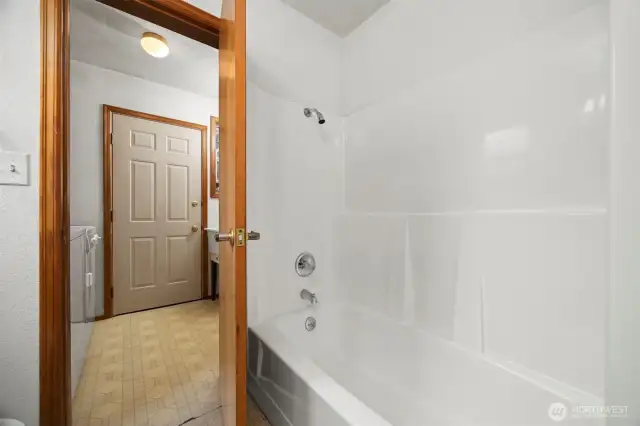 The large tub/shower with the back porch beyond.