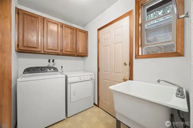The back porch/laundry room has a deep laundry sink and opens out to the carport and storage room.