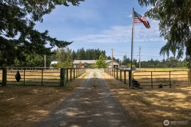 Looking at the driveway between the two smaller pastures that have run-in sheds and paddocks. Got to love that flag flying high!