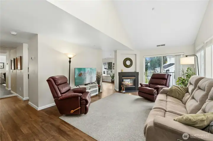 Living room from entry.  Slider in background opens to another deck. Valted ceiling has skylights.