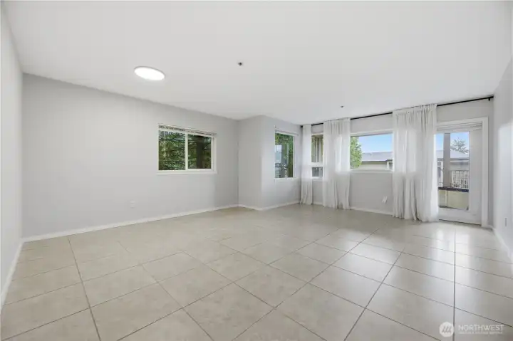 A spacious living area showcases durable tile flooring and large windows which let in an abundance of natural light to the home.