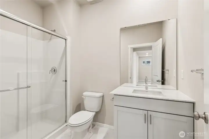 Main floor 3/4 bathroom with large shower, quartz counters with undermount sink and soft closing cabinets.