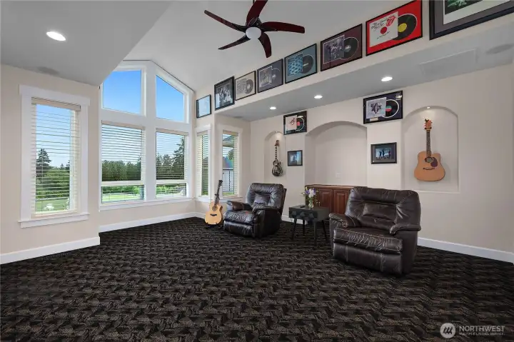 A spacious vaulted living room offers flexible living space with tall windows and display niches.