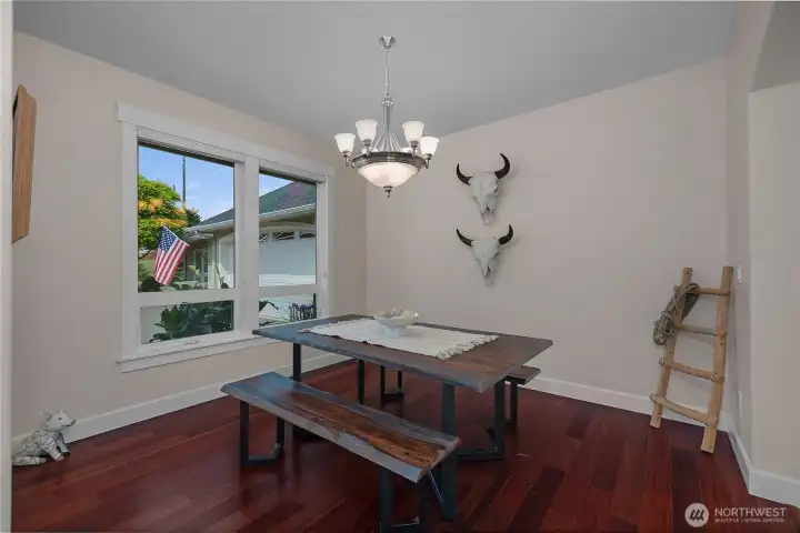 The dining room (just off the entry) is set apart with rich flooring, soft light, and a comfortable layout.