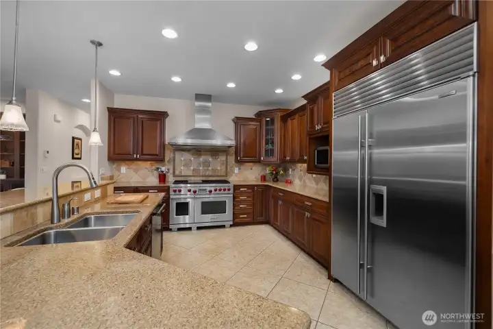 Cook with confidence using the Wolf range, custom cabinetry, and commercial-style Sub-Zero refrigerator.