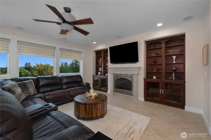 The inviting family room features a fireplace, built-in cabinetry, and views through wide windows.