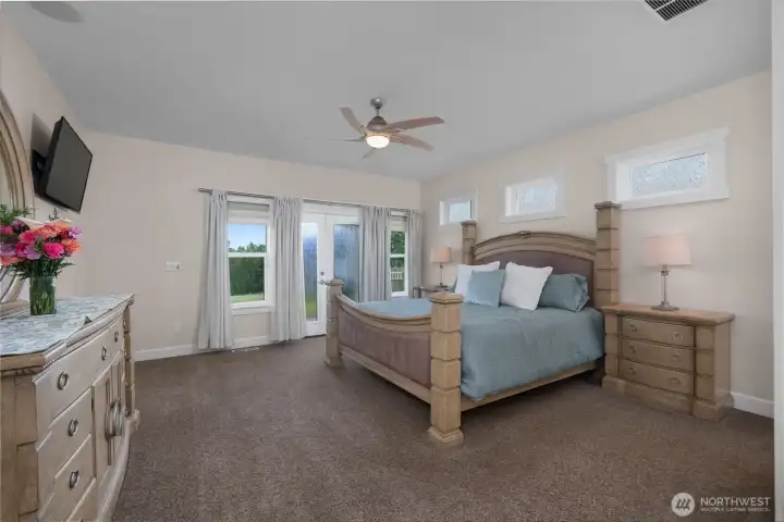 The primary bedroom offers generous space, soft natural light, and direct outdoor access.