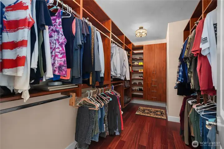The primary closet is thoughtfully designed with extensive built-ins and rich wood finishes.