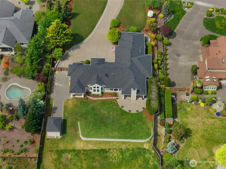 The overhead view shows the home’s footprint, outdoor living areas, and landscaped setting.