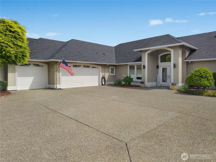 The front approach highlights the oversized driveway, attached 3-car garage, and welcoming entry.