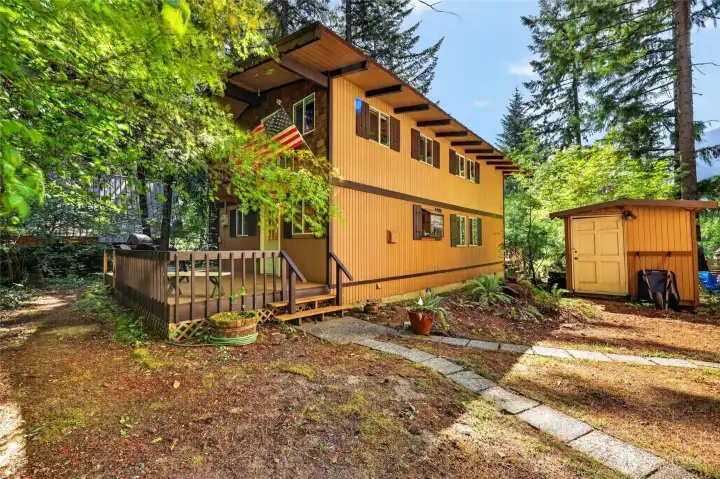 Front exterior of the mountain home featuring cedar siding, attached two-car garage, and a wooded setting in Packwood. Front exterior of the mountain home featuring cedar siding, attached two-car garage, and a wooded setting in Packwood.