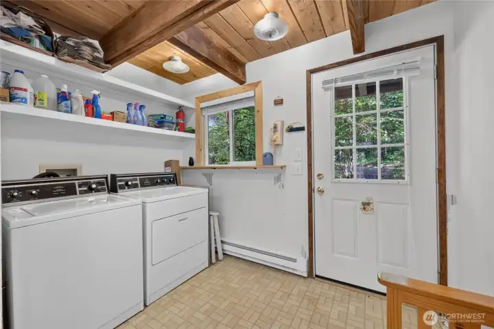 Laundry and mudroom with exterior access, built-in shelving, and utility sink. Laundry and mudroom with exterior access, built-in shelving, and utility sink.