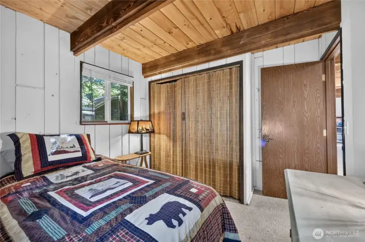 Secondary bedroom featuring wood ceilings and sliding closet doors. Secondary bedroom featuring wood ceilings and sliding closet doors.