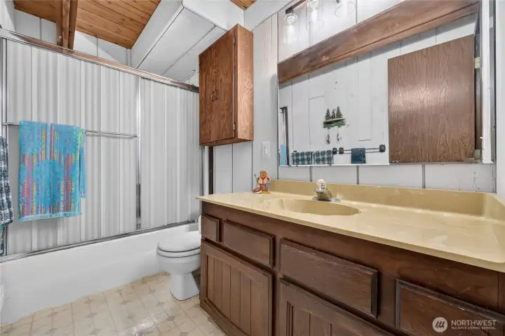 Main-level full bathroom with oversized vanity and tub/shower combination. Main-level full bathroom with oversized vanity and tub/shower combination.