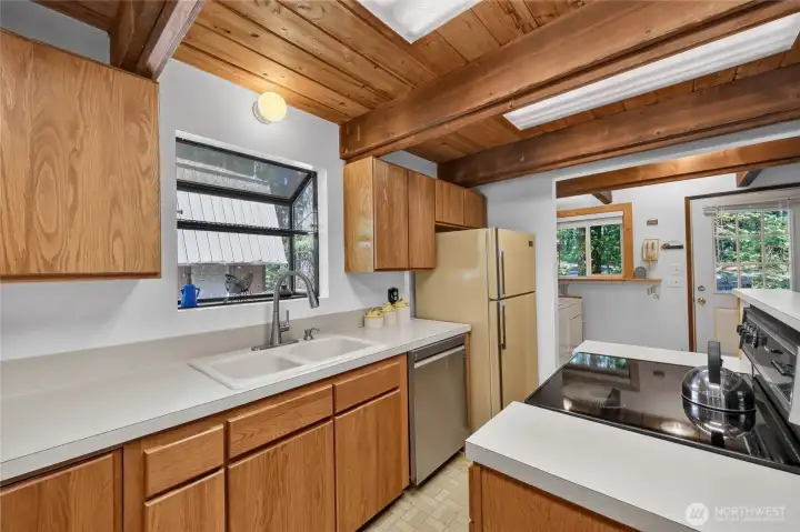 Alternate kitchen view showcasing efficient workspace and adjoining dining area. Alternate kitchen view showcasing efficient workspace and adjoining dining area.