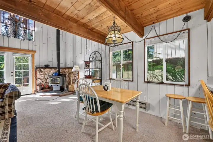 Dining area surrounded by large windows with views of the wooded property. Dining area surrounded by large windows with views of the wooded property.