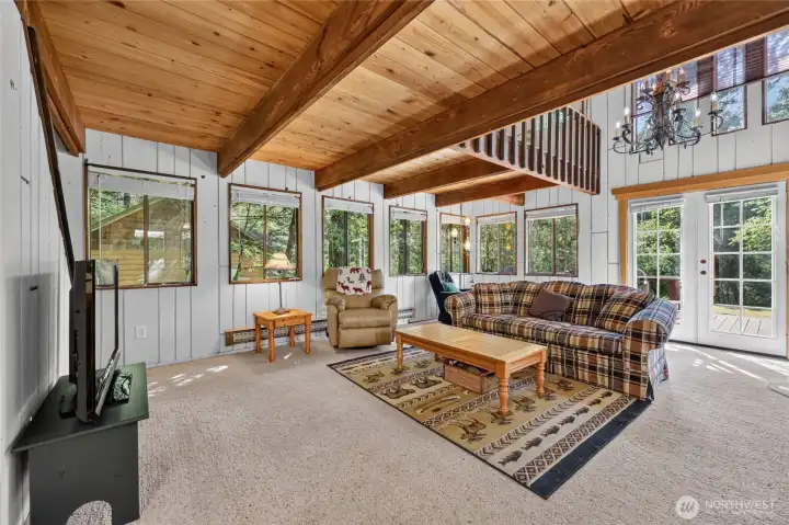 Spacious living area with abundant natural light and forest views. Spacious living area with abundant natural light and forest views.