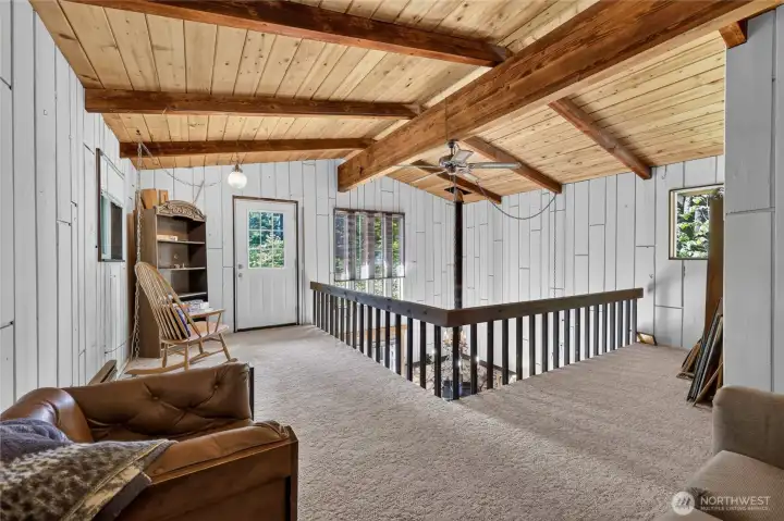 Open loft with views of the main living area and vaulted wood ceilings. Open loft with views of the main living area and vaulted wood ceilings.