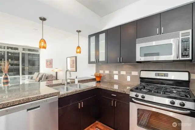 Modern kitchen with stainless steel appliances and granite countertops.