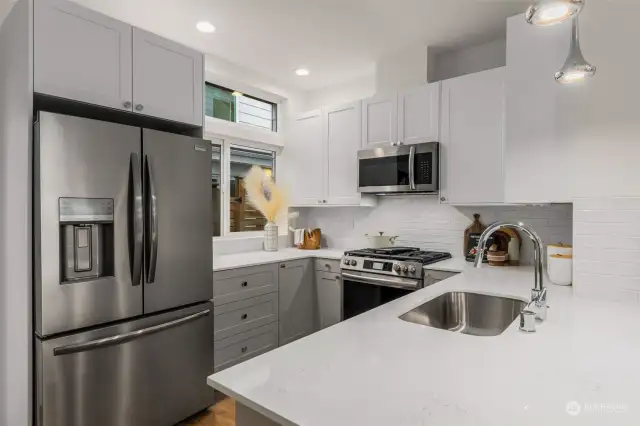 This contemporary kitchen enhances the hosting experience, featuring a window that invites abundant natural light.