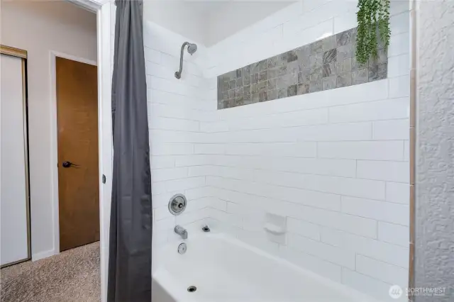 Updated bath with ceramic tile surround.