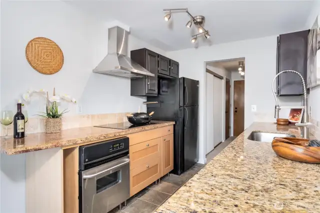 Slab granite, slate floor and stainless range hood.