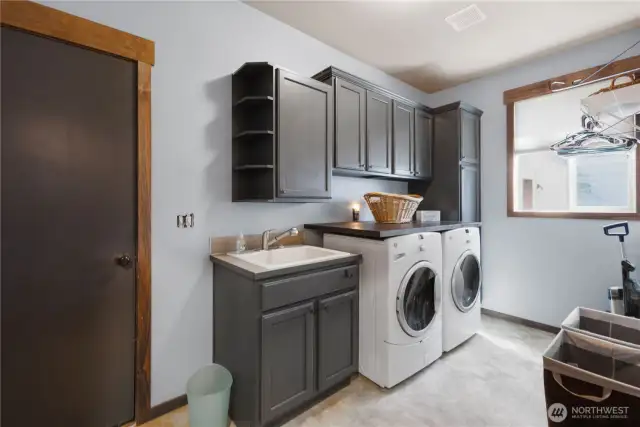 Main Level Laundry Room with cabinets and sink!