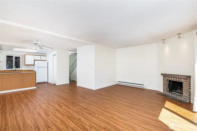 Main floor living area with wood burning fireplace and brand new floors throughout.