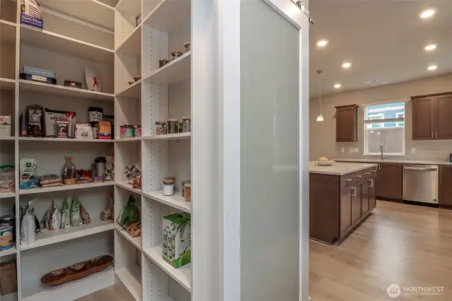 Custom built in pantry shelves with sliding barn door entry.