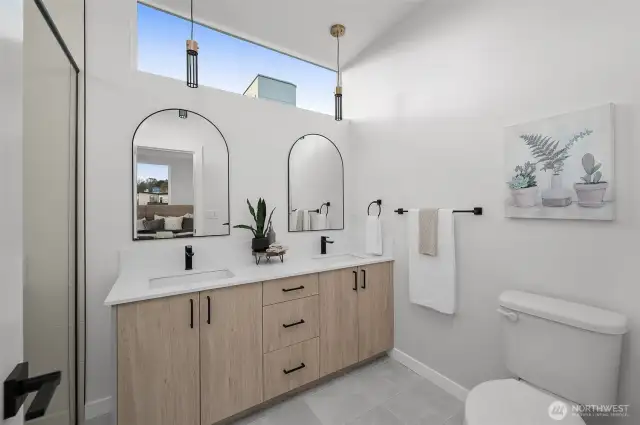 This stylish bathroom features a double vanity with sleek finishes, elegant pendant lighting, and thoughtful touches for your daily routine to feel like a spa experience.