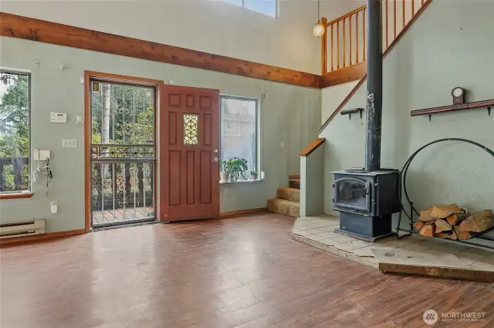 Entering home into the tall ceilinged Living & Dinng areas. Stairs lead to upstairs bedrooms, bath and hallways that once were lined with bookshelves