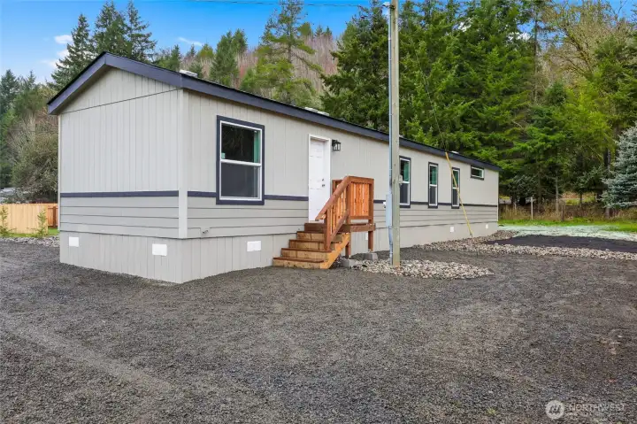 Back entrance of home with gravel pad