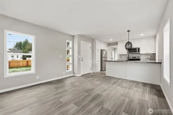 Main entrance leads into living room. Linoleum throughout home. Fun windows flank the front door.