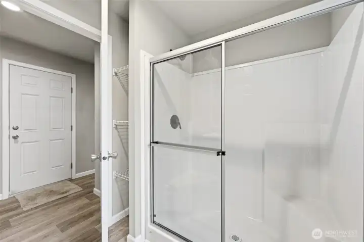 Shower with built in bench and small storage/linen space